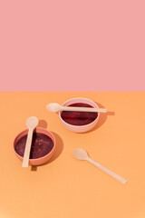 Plates with beetroot soup, borscht on yellow table, abstract composition. Conceptual art, healthy still life, copy space