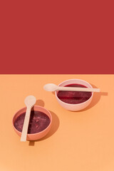 Plates with beetroot soup, borscht on yellow table, abstract composition. Conceptual art, healthy still life, copy space