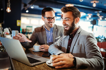 Happy young attractive business man friends talking in cafe urban