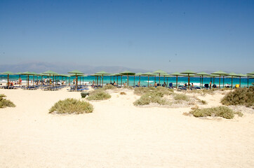 sand beach with umbrellas and sea on the island Chrisi, Crete