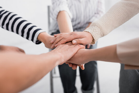 partial view of group of women holding hands together during seminar