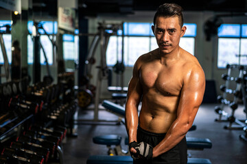 Fototapeta na wymiar portrait photo of muscular man wearing sportswear bodyweight doing exercise for bodybuilding workout in fitness gym. fitness training, bodyweight building and workout exercise concept