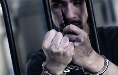 Upset handcuffed man smoking with a knife imprisoned for crime, punished for serious villainy....