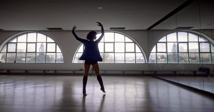 African-american woman dancing spinning around in dance studio