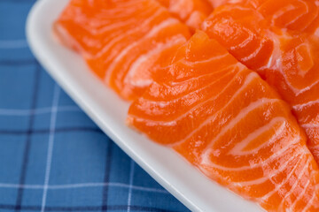 Salmon raw sashimi on whiteJapanese traditional dish on blue tablecloth.
