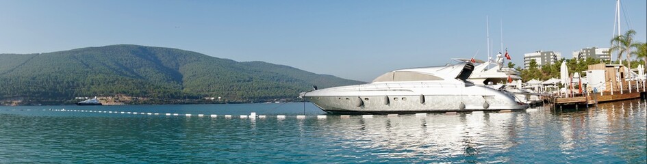 Naklejka premium Bodrum, Turkey - August, 2020 Stunning panoramic view of island with palm trees, white sand, turquoise ocean water and blue sky, Water bungalow, white boats