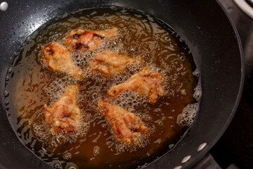 Close up fried chicken wings in boiling oil