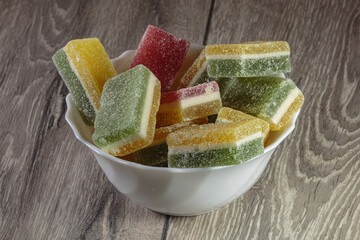 Multi colored layered marmalade in a dish. Closeup of wonderful dessert.