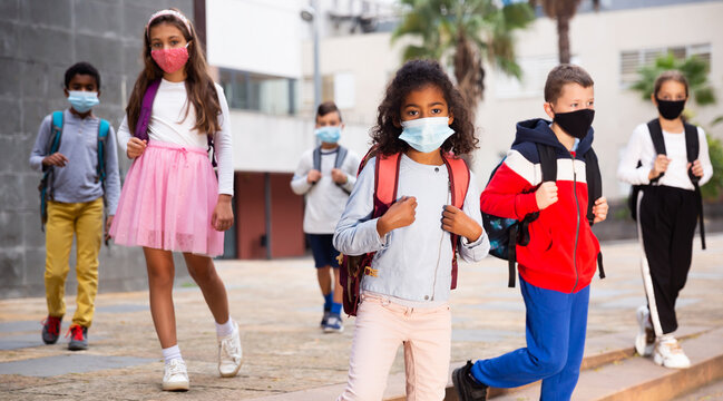Portrait of tween girl in medical face mask on her way to college on warm autumn day. Forced precautions in COVID pandemic