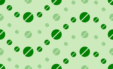 Seamless pattern of large and small green pill symbols. The elements are arranged in a wavy. Vector illustration on light green background