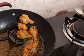 Close up fried chicken wings in boiling oil