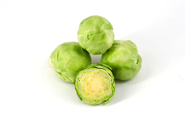 Brussels sprouts, with the central sprout cut in half, on a white background.