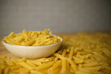 A plate of pasta on a blurry background. Pasta all over the frame. Shooting at an angle. Selective focus. Blurring