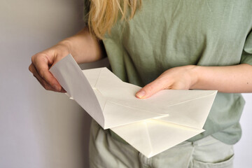 Woman holds in hand paper envelope. New mail, message. Postal service. Young girl want send or...