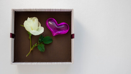 Gift brown box with a heart and a white rose. The concept of Valentine's Day, Anniversary, Mother's Day and birthday greetings. Top view. Place for your text