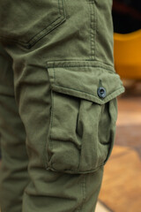 Image of a detail of a man's resting at the side of his pant leg with his thumb in his pocket