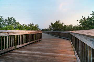 Fototapeta premium Evening with wooden walkway leading off into the distance at Hershel B King Park at Flager Florida
