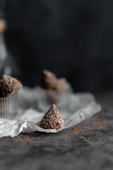 
Homemade chocolates with coconut flakes and cocoa powder on a gray concrete table. Sweets background. view from above.