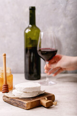 Goat cheese served with honey and bottle of red wine