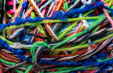 textured background of a tangle of multicolored yarn threads of different colors and thicknesses