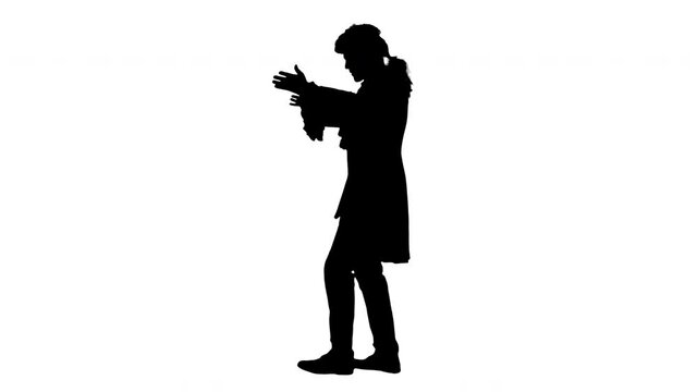 Silhouette Man dressed like Wolfgang Amadeus Mozart conducting an orchestra.