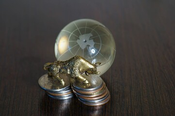 A metal bull and a glass globe on the table.