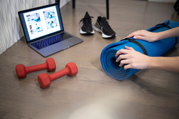 Young sporty slim woman preparing for online fitness training with modern laptop. Healthy lifestyle concept, online fitness and sport lessons. Sport online.