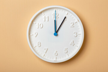 white wall clock with blue second hand show one o'clock
