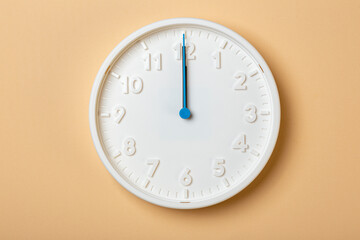 white wall clock with blue second hand show twelve o'clock