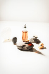 Glow Face Serum in crystal  bottle on the  stone with seashells. Skin care concept.  copy space