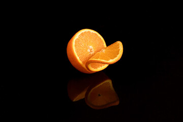 half orange with a slice on black