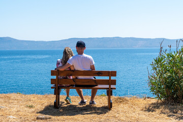 Silhouette of a heterosexual couple enjoying the afternoon on a calm and peaceful relaxing in front of the ocean view. Copy space above with room for text.