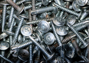 A bunch of screws close-up, top view, background. Hardware, fasteners and materials for construction and repair. a bunch of screws. A pile of iron. Fasteners, industrial