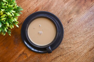 View from above of a cup of coffee on the wooden table 