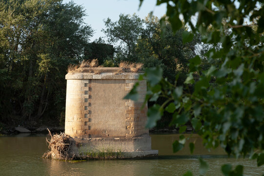 An old support pylon in the middle of the Ebro river, a vestige of the disappeared train tracks of the Gallur to Sadaba railway line, Aragon, Spain.