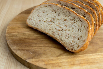 Multigrain bread. Fresh bakery. Slices of multigrain bread on a cutting board. Close-up. Flat layout.