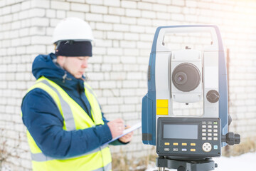 engineer surveyor works with an electronic total station, a tool for performing geodetic,...