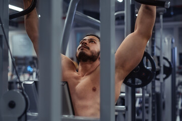 Bodybuilder working out in gym with determination