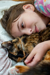 teenage girl in pajamas sleeping on a pillow with a domestic cat