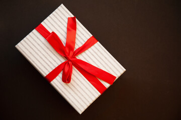 Background for Valentine's Day greeting card. Valentine's Day concept. Red gift ribbons, gifts, hearts on a dark textured background. View from above.