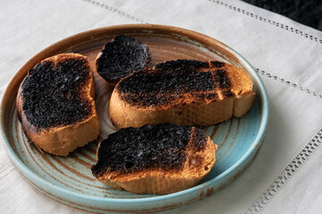Burnt toast bread on a plate on a white tablecloth