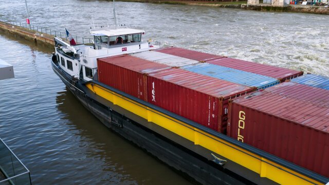 Boissise le roi. France. January 23. 2021. Industrial transport boat. Barge containing containers for the transport of merchandise. Passage in a lock of Seine river.	