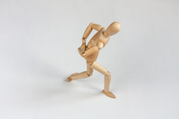 a bent wooden mannequin suffering from backache