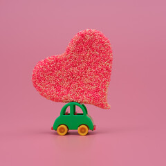 Mini toy car carrying big heart. Funny love and Valentine's day celebration concept