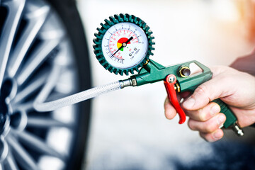 Close up car mechanic inflating tire