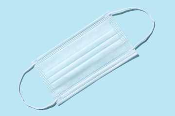 Medical surgical protective mask. On a blue background. Covering the mouth and nose. Protection concept.