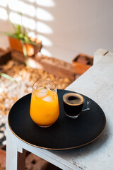 Glass of espresso with orange juice on wooden table and copy space, Summer Cocktail, Cold brew coffee or black tea. (close up, selective focus),