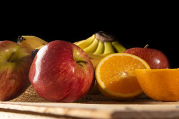 Orange, orange cut in half, apples and bananas on rustic wooden surface and rustic fabric,...