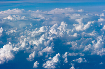 Cumuluswolken am blauen Himmel vom Flugzeugfenster aus gesehen