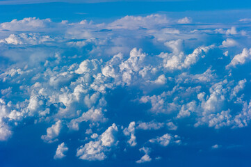 Cumuluswolken am blauen Himmel vom Flugzeugfenster aus gesehen